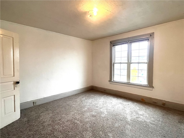 carpeted empty room featuring a textured ceiling