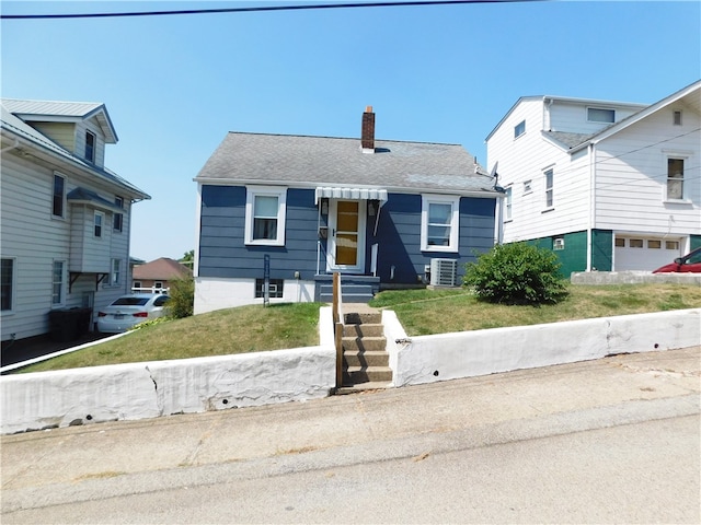 view of front facade with central AC unit and a front lawn