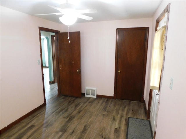 unfurnished room featuring ceiling fan and dark wood-type flooring