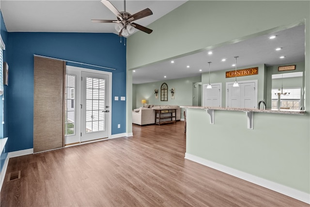 unfurnished living room with ceiling fan, hardwood / wood-style flooring, and high vaulted ceiling