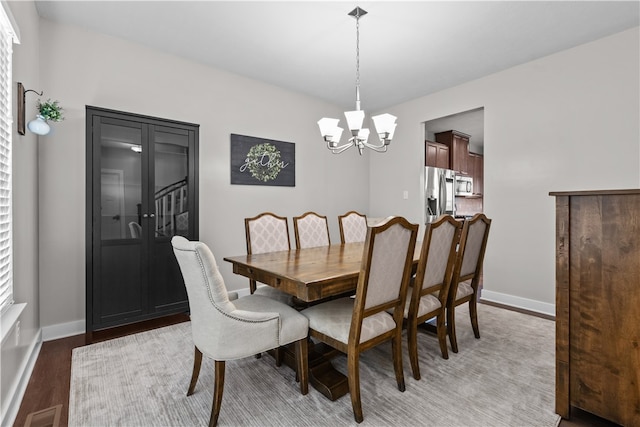 dining space featuring a notable chandelier and dark wood-type flooring