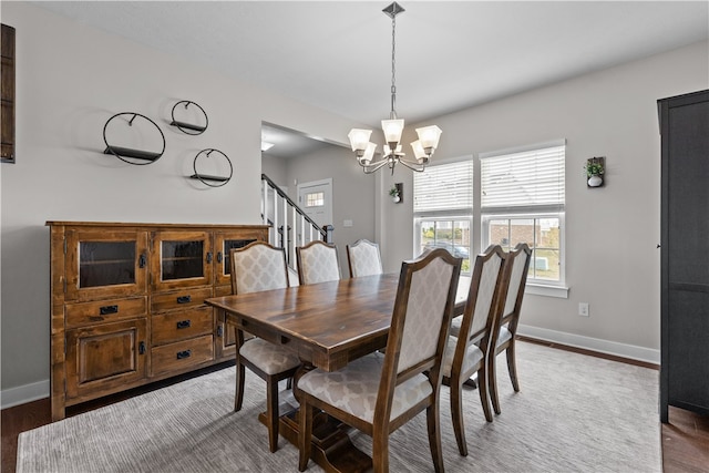 dining area with a notable chandelier and dark hardwood / wood-style floors