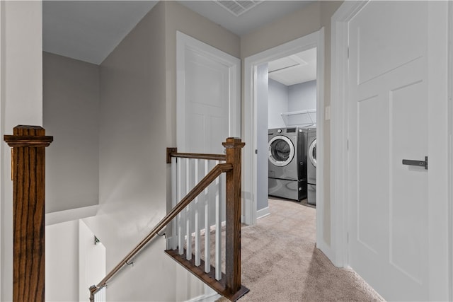 hall with light carpet and washer and clothes dryer