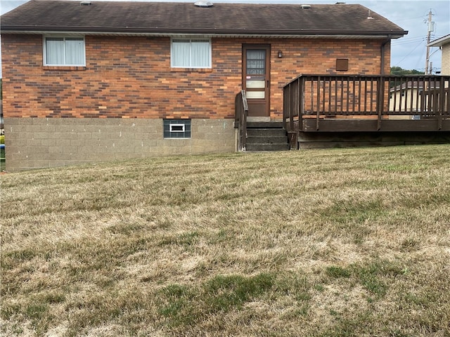 rear view of property featuring a deck and a lawn