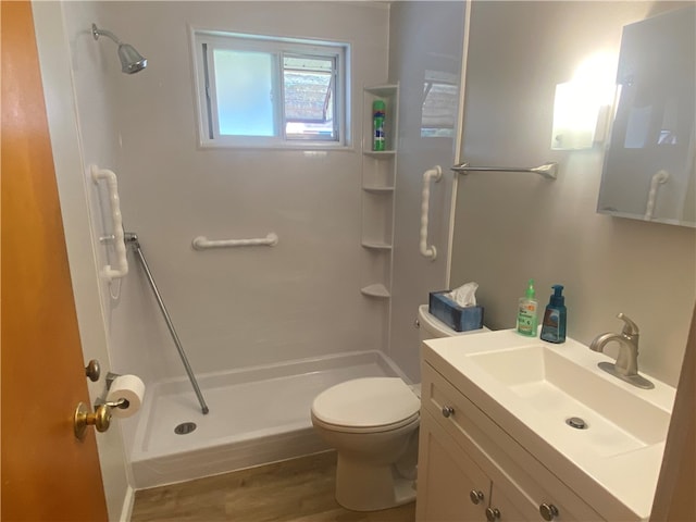 bathroom with a shower, vanity, toilet, and hardwood / wood-style flooring