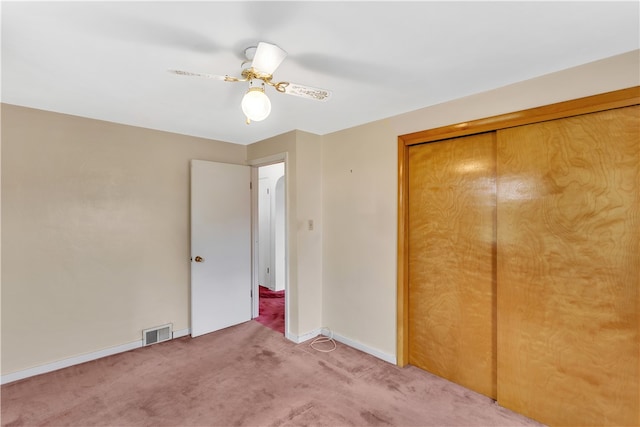 unfurnished bedroom with carpet flooring, a closet, and ceiling fan