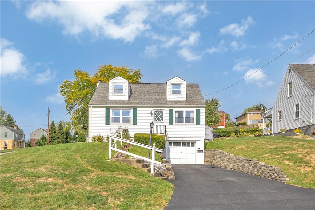 cape cod house with a front yard and a garage