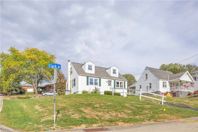 cape cod home with a front lawn