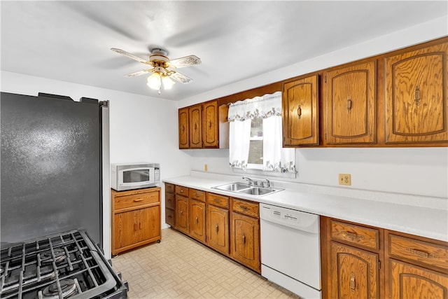 kitchen featuring white appliances, sink, and ceiling fan