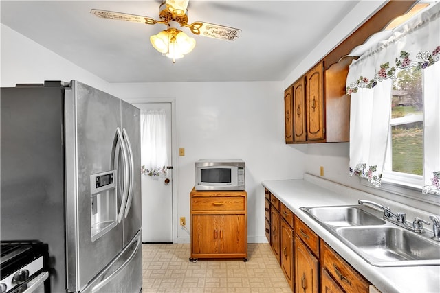 kitchen featuring appliances with stainless steel finishes, sink, and ceiling fan