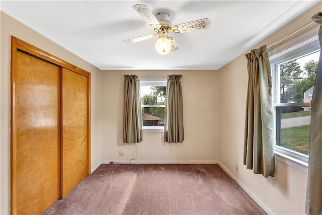 unfurnished bedroom with ceiling fan, a closet, and dark carpet