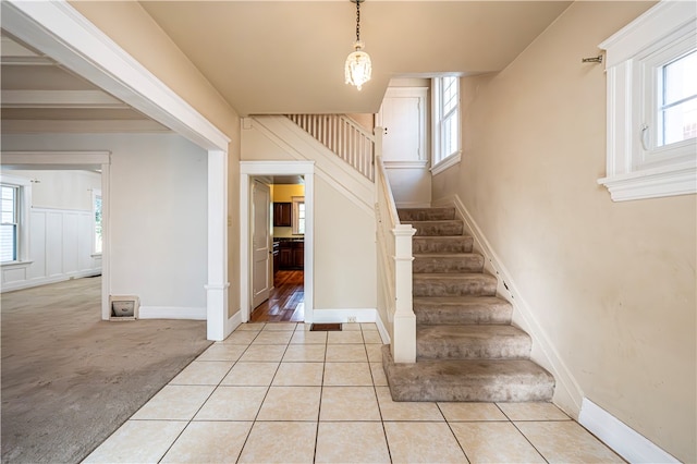 stairs featuring plenty of natural light and carpet flooring