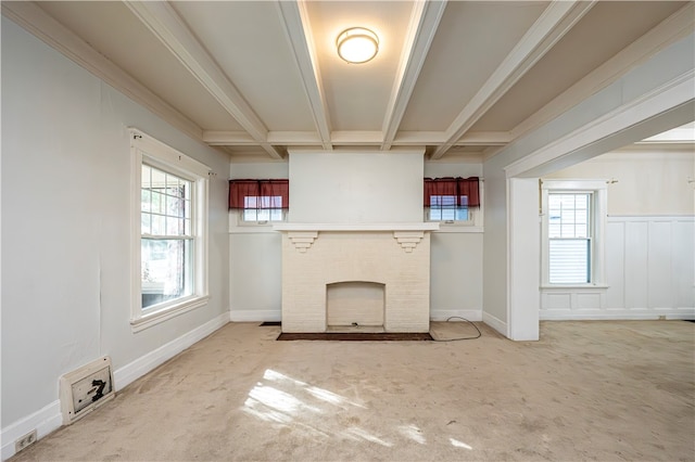 unfurnished living room with carpet floors, beam ceiling, ornamental molding, and a brick fireplace