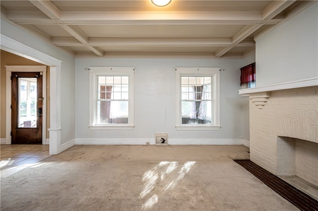 unfurnished living room featuring a brick fireplace, beamed ceiling, light colored carpet, and coffered ceiling