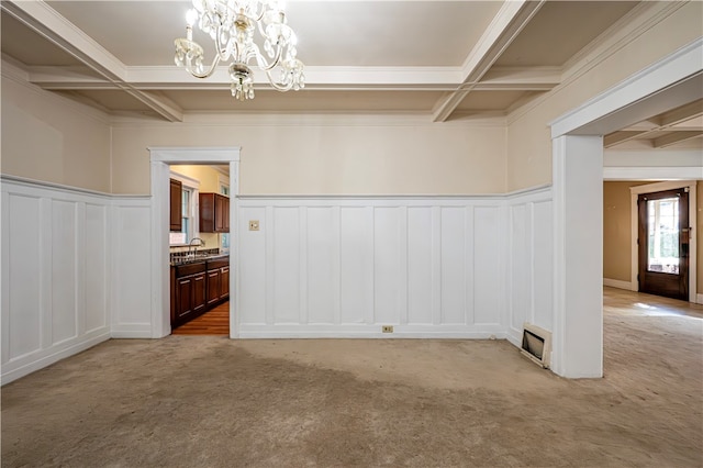 interior space featuring light carpet, coffered ceiling, beamed ceiling, and an inviting chandelier