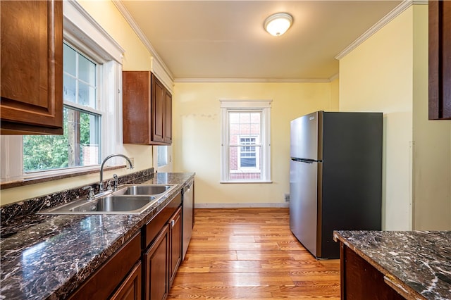 kitchen featuring ornamental molding, light hardwood / wood-style floors, appliances with stainless steel finishes, and sink