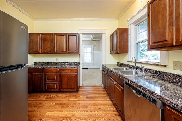 kitchen featuring light hardwood / wood-style floors, appliances with stainless steel finishes, sink, and a wealth of natural light