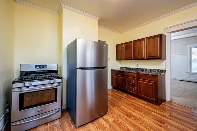 kitchen with stainless steel appliances, crown molding, light hardwood / wood-style floors, and dark stone counters