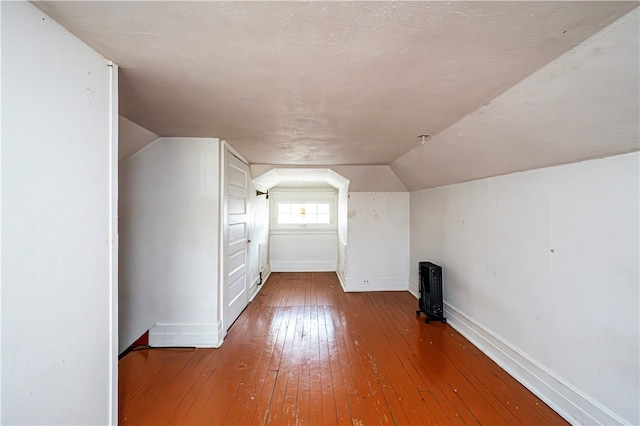 bonus room featuring a textured ceiling, wood-type flooring, and lofted ceiling