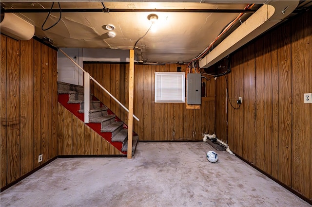 basement with wooden walls and electric panel