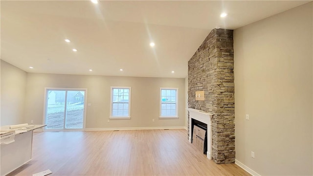 unfurnished living room featuring a fireplace and light hardwood / wood-style floors