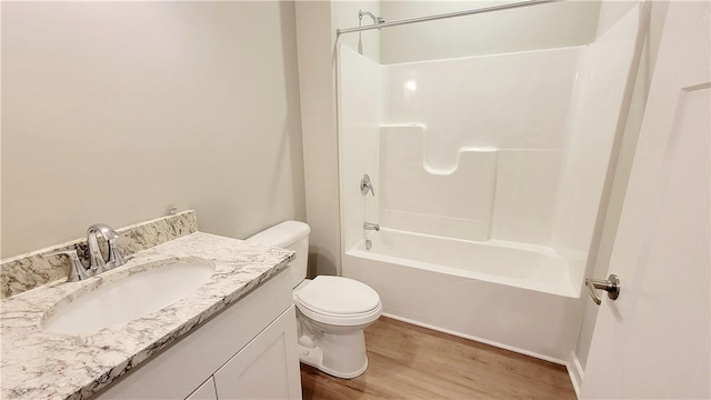 full bathroom with vanity, bathing tub / shower combination, hardwood / wood-style flooring, and toilet