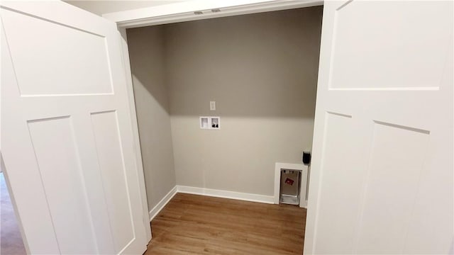 clothes washing area with light hardwood / wood-style floors and hookup for a washing machine