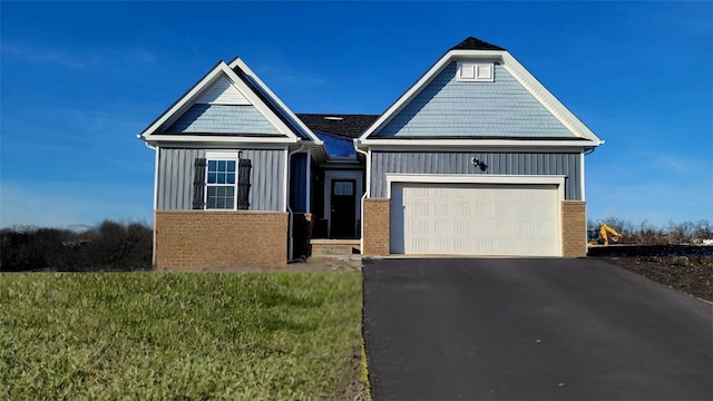 view of front of property featuring brick siding, board and batten siding, driveway, and a garage