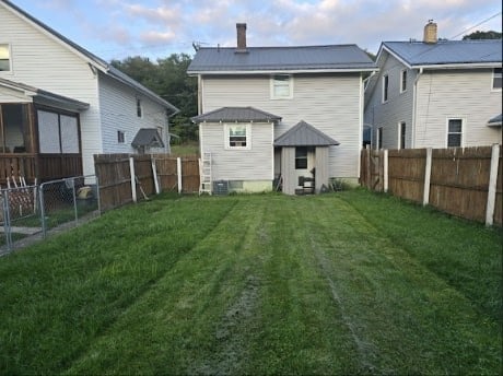 rear view of property featuring a lawn