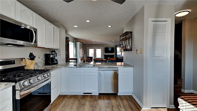 kitchen featuring white cabinetry, light hardwood / wood-style floors, appliances with stainless steel finishes, and sink