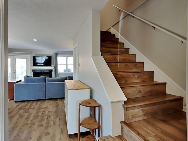 stairs featuring a wealth of natural light, french doors, and hardwood / wood-style flooring