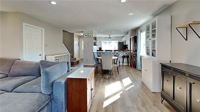 living room featuring light wood-type flooring and ceiling fan