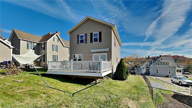 rear view of house featuring a yard and a deck