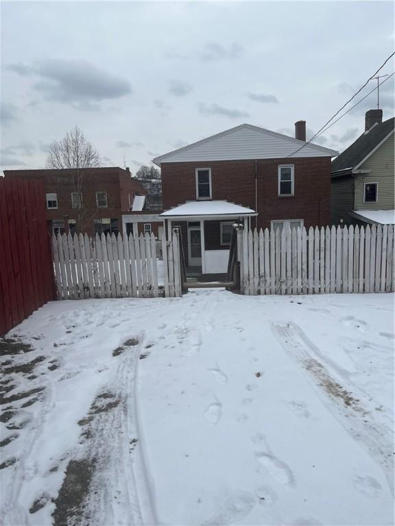 view of snow covered back of property