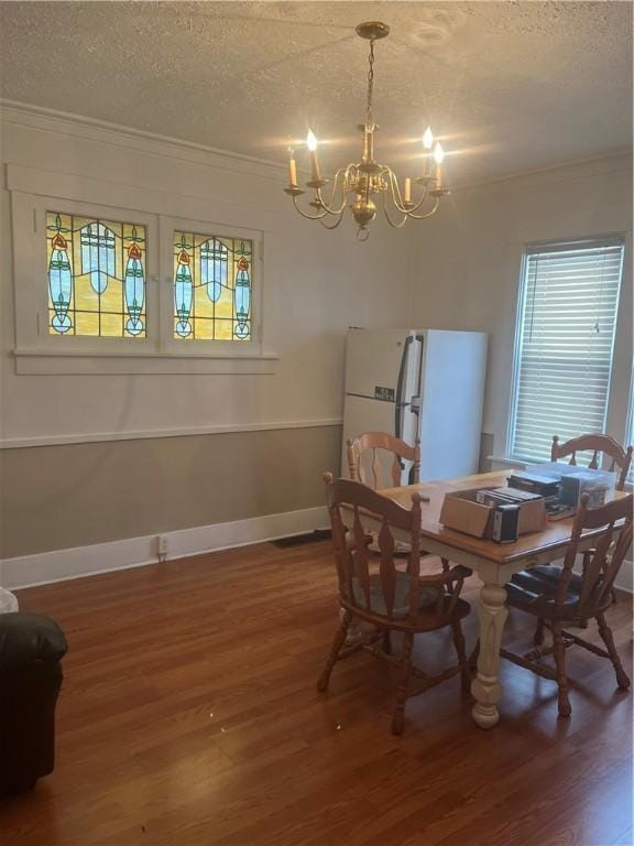 dining space featuring a textured ceiling, dark hardwood / wood-style floors, and a notable chandelier