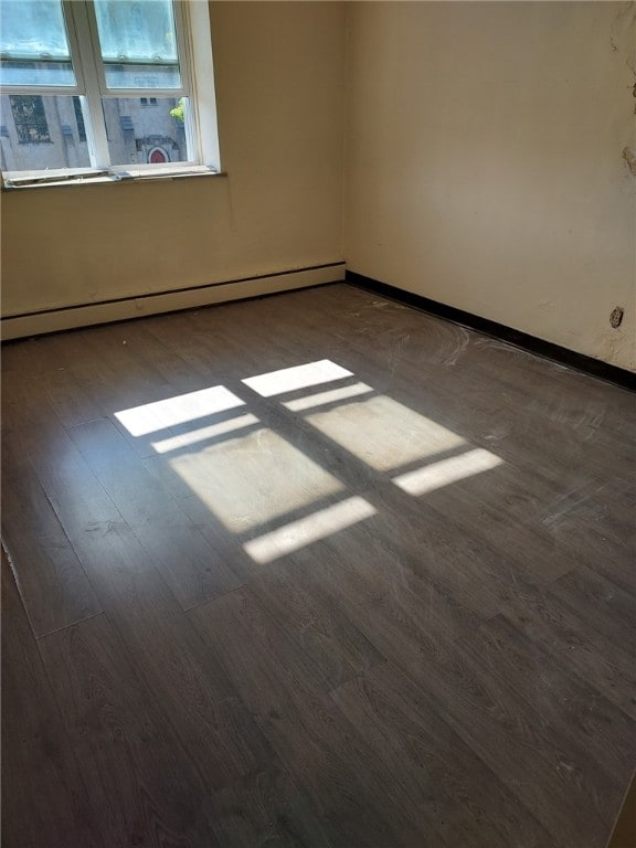 unfurnished room featuring a baseboard radiator and hardwood / wood-style floors