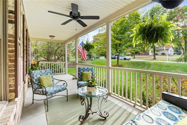 wooden terrace with a lawn, ceiling fan, and a porch