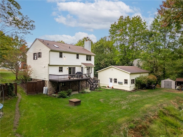 rear view of house featuring a wooden deck, a storage unit, and a yard