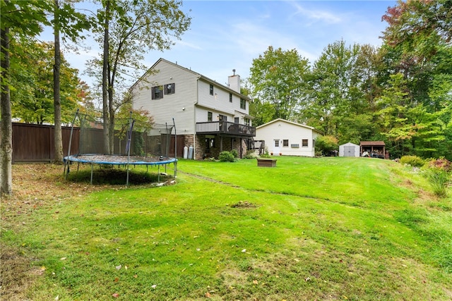 view of yard with a shed, a wooden deck, and a trampoline