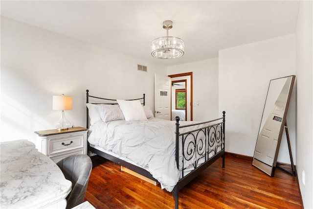 bedroom featuring a notable chandelier and dark hardwood / wood-style floors