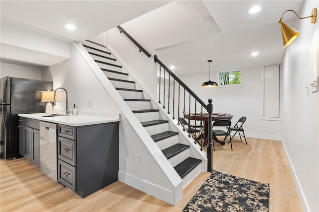 stairway with sink and wood-type flooring