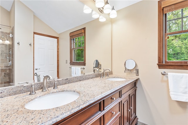 bathroom featuring walk in shower, vanity, and vaulted ceiling