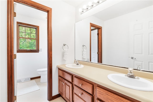 bathroom featuring vanity, tile patterned floors, and toilet