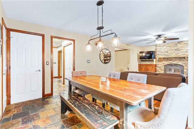 dining space featuring a fireplace and ceiling fan