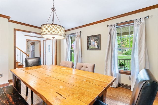 dining space with ornamental molding and hardwood / wood-style flooring