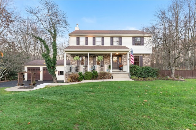 view of front of home with a garage, a front yard, and covered porch