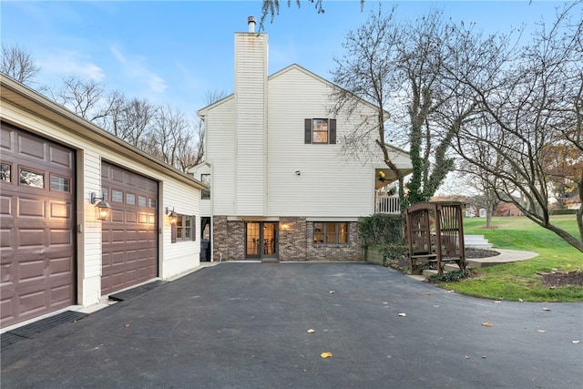 view of side of home with a garage and a lawn