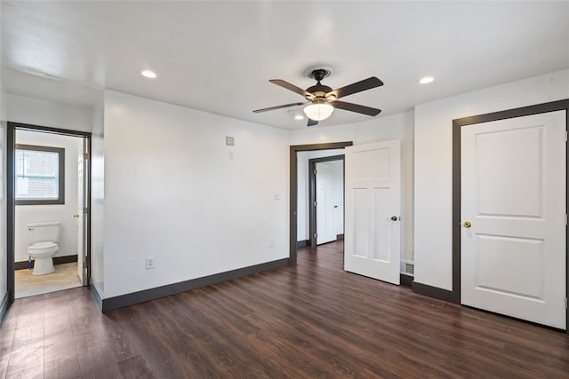 unfurnished bedroom featuring ceiling fan, dark wood-type flooring, and ensuite bath