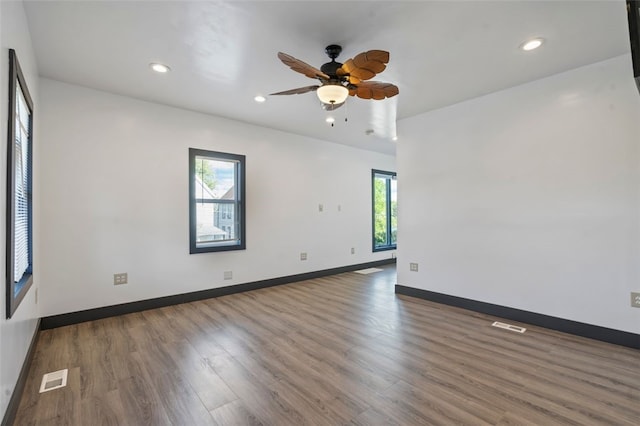 spare room featuring ceiling fan, dark hardwood / wood-style flooring, and a wealth of natural light