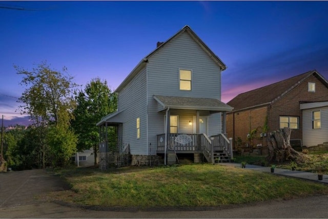 front facade with a yard and covered porch